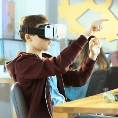 Kid in classroom using VR headset to learn