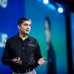 Man in black shirt giving speech on stage